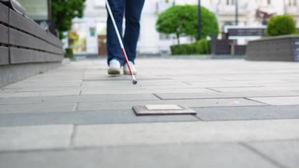 Young blind man with with a cane alone outdoors. Male person wearing glasses and casual clothes. Independence concept — Stock Video