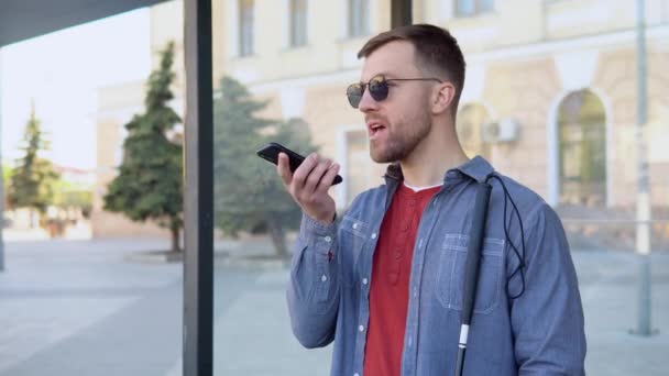 Seorang pria buta berbicara di telepon di bus berhenti — Stok Video