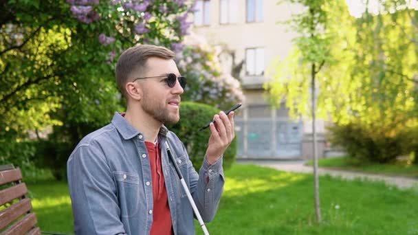 Blind man med funktionshinder med hjälp av digital assistent och lättillgänglighet funktioner på smartphone — Stockvideo