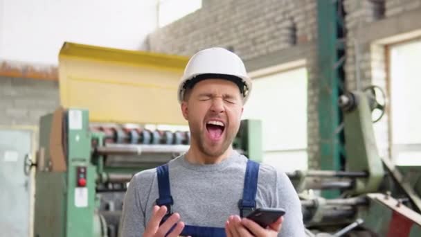 Un trabajador profesional alegre canta y baila en un taller industrial — Vídeo de stock