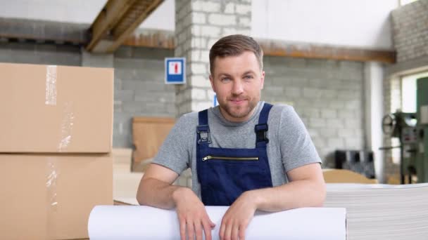 En professionell arbetare i uniform med en stor pappersrulle i ett tryckeri — Stockvideo