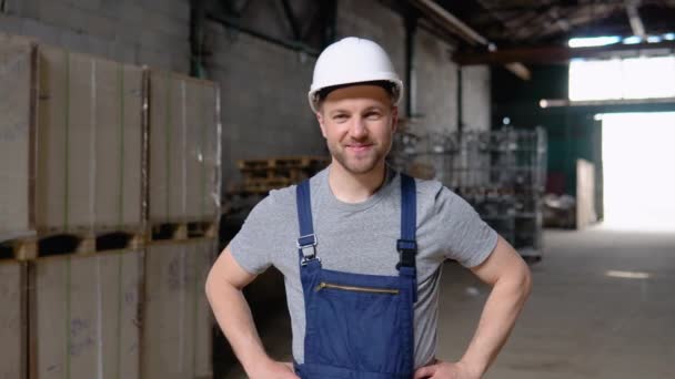 Portrait d'un travailleur essentiel de première ligne dans un entrepôt. En arrière-plan grand entrepôt — Video