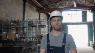 Profesyonel işçi lojistik merkezi depo fabrikasında yürüyor. İnşaat alanı lojistik mimarı. Kapalı alanda inşaatçı.