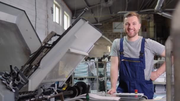 Porträtt av en ingenjör på en tryckfabrik. Industriellt tryck av affischer, tidningar, foldrar och tidskrifter — Stockvideo