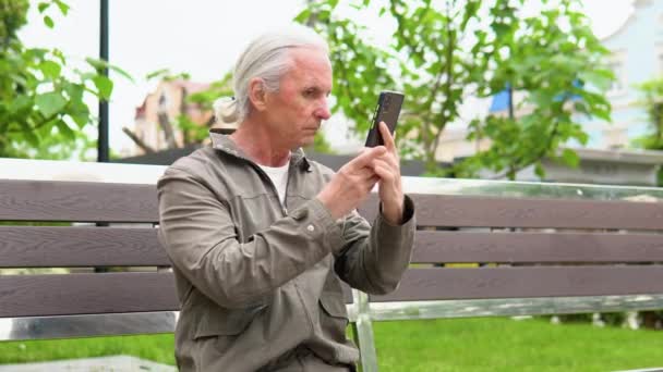 Starší Muž Dělá Účes Při Pohledu Přední Kamery Svého Telefonu — Stock video