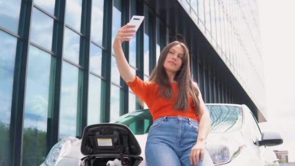Жінка Бере Селфі Заряджаючи Електромобіль Біля Торгового Центру Екологічні Екологічні — стокове відео