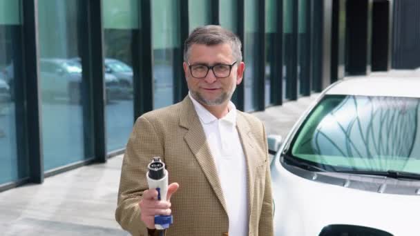 Older Man Stands Charger Her Electric Car Plug Charging Electric — Stock Video