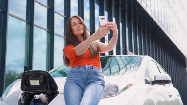 Kadın Alışveriş Merkezinin Yakınında Elektrikli Araba Şarj Ederken Selfie Çekiyor — Stok video