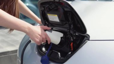 Kız elektrikli arabasını şarj etmeye başlıyor.