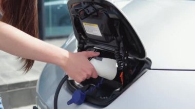 Kız elektrikli arabasını şarj etmeye başlıyor.