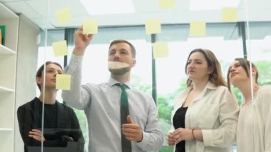 Bir grup genç girişimci şirket toplantı odasında iş konuşuyorlar.