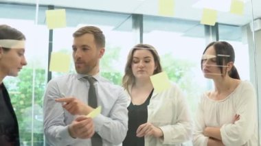 Bir grup genç girişimci şirket toplantı odasında iş konuşuyorlar.