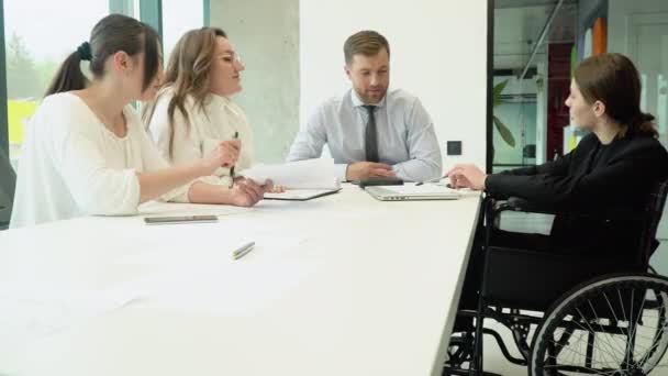 オフィスミーティングや車椅子で話す多様な仕事仲間たち 近代的なオフィスで独立した創造的なビジネスを — ストック動画