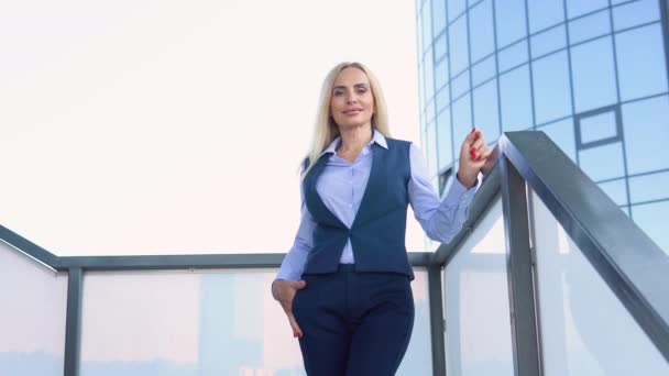 現代的な企業ビルの外に立つ幸せなオフィスの女性経営者 — ストック動画