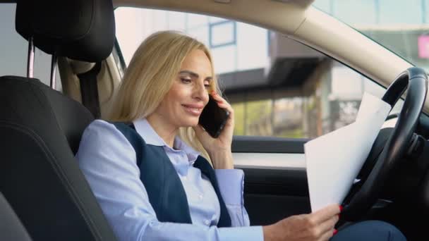 自信のある女性が現代的なオフィスビルの近くのビジネススーツの車に座っている電話で話す — ストック動画