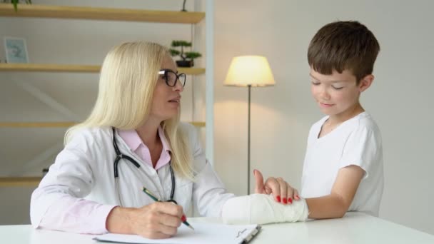 Sorrindo Médico Família Sênior Feminino Uniforme Consulta Pequena Paciente Criança — Vídeo de Stock