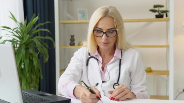 Kadın Doktor Tıbbi Kayıt Defterine Bilgi Yazıyor Ofiste Çalışan Olgun — Stok video