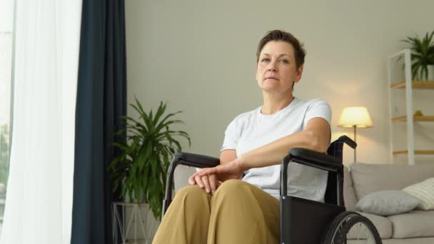 成熟而悲伤的女人坐在轮椅上看着镜头 — 图库视频影像