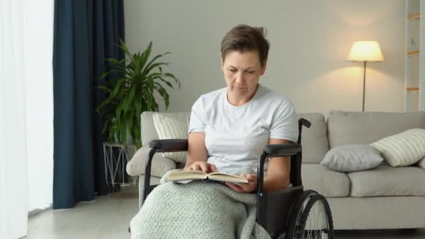 坐在轮椅上看书的老年妇女 — 图库视频影像