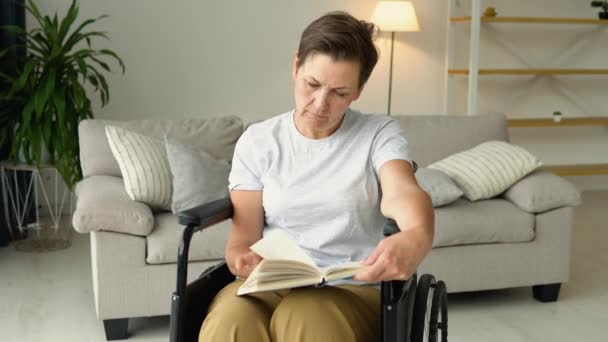 Starší Žena Sedí Invalidním Vozíku Čte Doma Knihu — Stock video