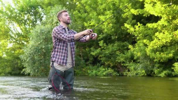 川に釣竿を持つ漁師 ブラウン フィッシュ夏休みと人々の概念 フックにトラウト ブラウン トラウトをマスのフライフィッシング — ストック動画