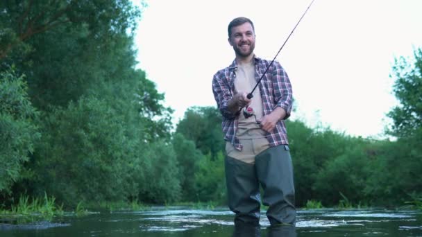 川に釣竿を持つ漁師 ブラウン フィッシュ夏休みと人々の概念 フックにトラウト ブラウン トラウトをマスのフライフィッシング — ストック動画