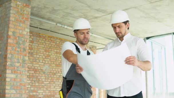 Two Young Engineer Standing Looking Building Site Wearing Safety Helmet — Αρχείο Βίντεο