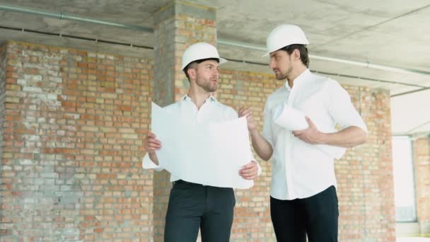 Zwei Männer Mit Helm Betrachten Den Plan Des Gebäudes — Stockvideo