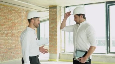 Close up of handshake in construction site. Friendly handshake of two builders at a construction site