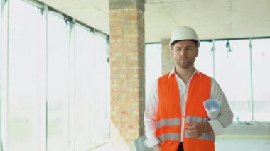 Engineer developer in helmet inspecting building. Builder constructor specialist