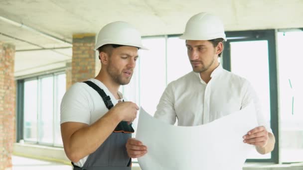 Two Young Engineer Standing Looking Building Site Wearing Safety Helmet — Stockvideo