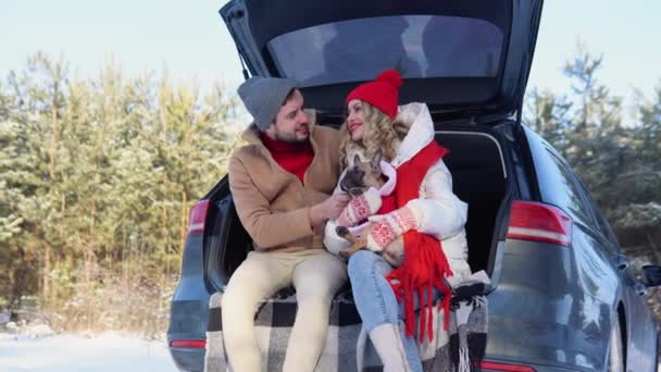 Young Couple Man Woman Dog Sitting Trunk Car Winter Hugging — Video