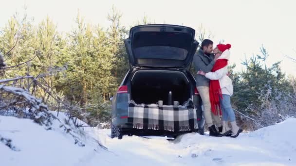 Young Couple Man Woman Hugging Kissing Car Winter Snowy Forest — Stockvideo