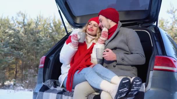 Young Couple Man Woman Sitting Trunk Car Winter Snowy Forest — Stockvideo