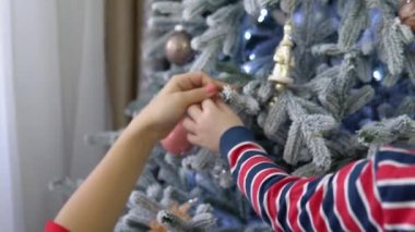 Noel ağaç evde süslemek için küçük çocuk yardım anne