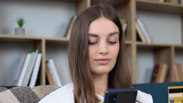 Close Smiling Young Girl Holding Smartphone Banking Credit Card Involved — Video