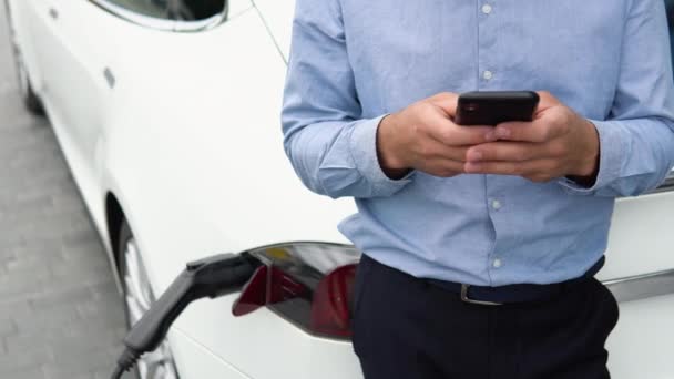 Fechar Mão Homem Segurando Smartphone Perto Carregar Carro Elétrico Carro — Vídeo de Stock