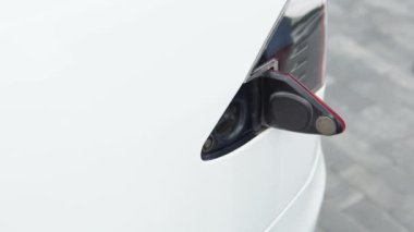 Close up man inserting power cable supply for charging electric car.