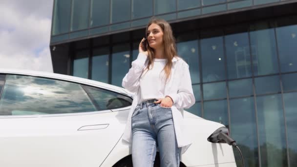 昼間の電気自動車充電ステーションの女性 真新しい車両 — ストック動画