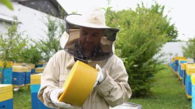 Closeup portrait of beekeeper holding a bee wax. Beekeeping concept. Beekeeper harvesting honey.