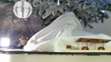 Christmas train traveling under a Christmas tree with gift bag