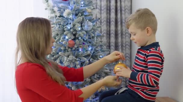 Mutter Hilft Kleinem Jungen Beim Schmücken Des Weihnachtsbaums Hause — Stockvideo