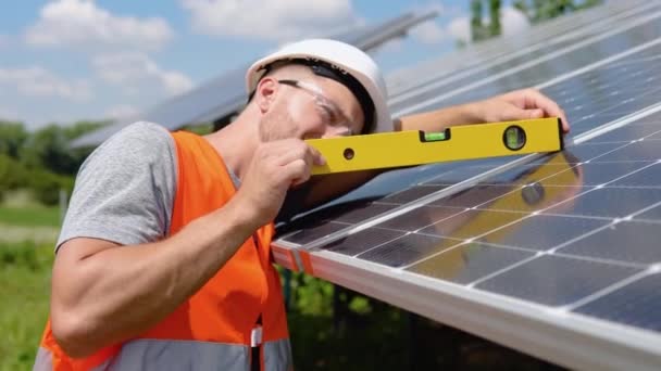 太陽電池パネルをインストールするワーカーは角度が正しいことを確認レベルを使用します — ストック動画