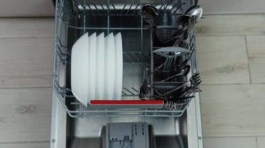 Filling dirty dishes in the dishwasher.Timelapse, 4K