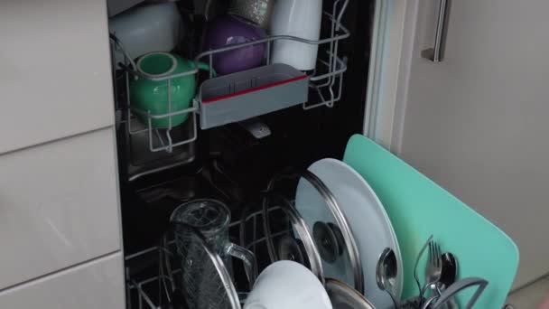 바구니를 꺼내고 뚜껑을 스타인 식기세척기에서 식기류를 부엌에 넣는다 가정생활 — 비디오