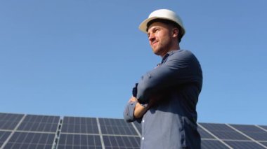 Üniformalı, büyük güneş pilleriyle sahada duran gururlu endüstriyel mühendisin portresi. Ekolojik çiftlik. Güneş enerjisi santrali. - İnsanlar. Sürdürülebilir enerji. Güneş enerjisi alanı. Ekoloji.