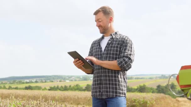 Farmer Wheat Field Holding Digital Tablet Showing Thumb Smiling Combine — Vídeo de stock