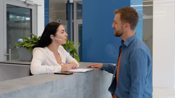 Woman Reception Consultant Helps Client Business Center — Αρχείο Βίντεο