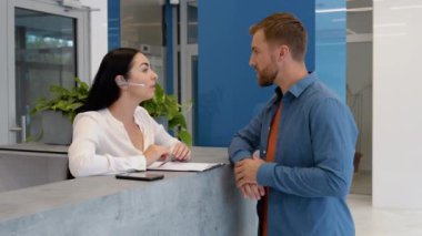 Woman reception consultant helps the client of business center.