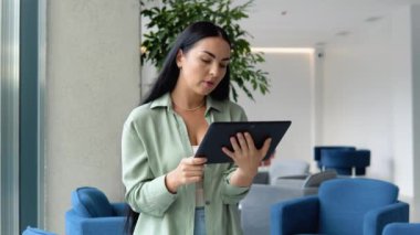 Freelance business woman using tablet working call video conference with customer in workplace at cafe.